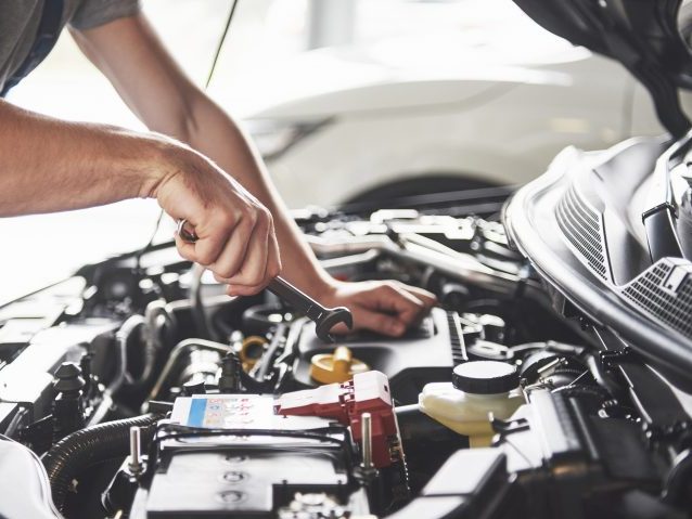 Picture showing muscular car service worker repairing vehicle